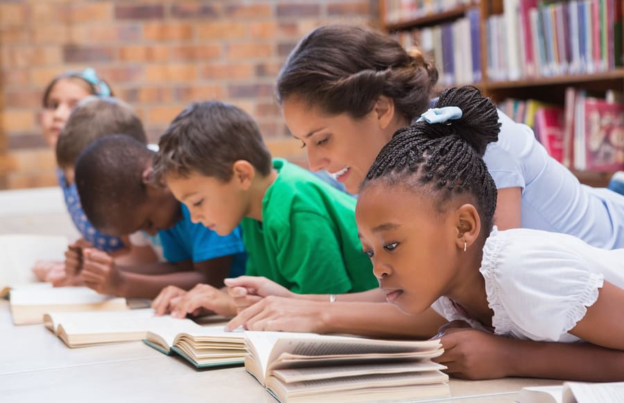 Children reading with their teacher.