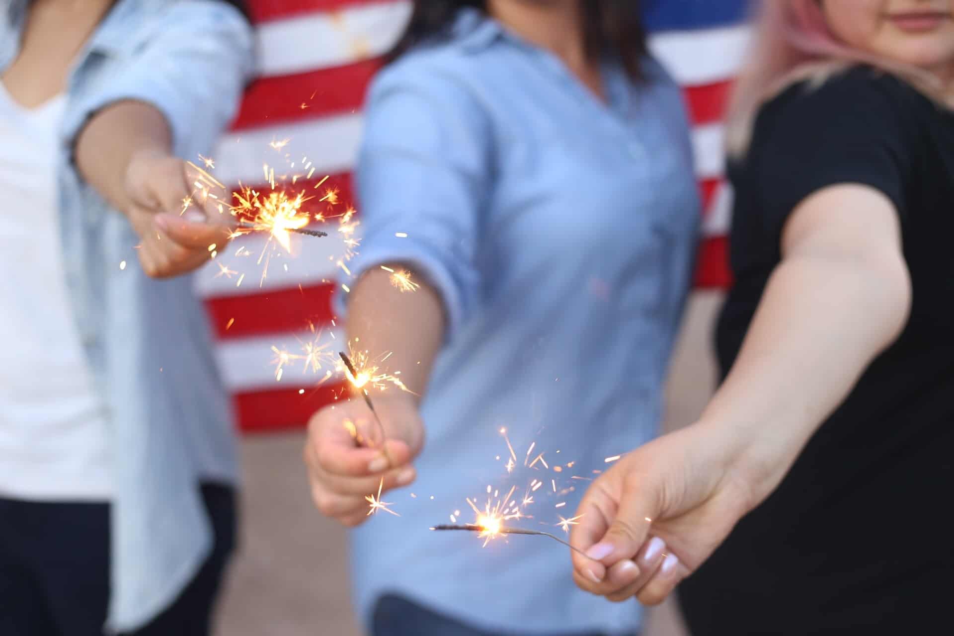 Group of people holding sparklers with The Spirit of Independence Day 