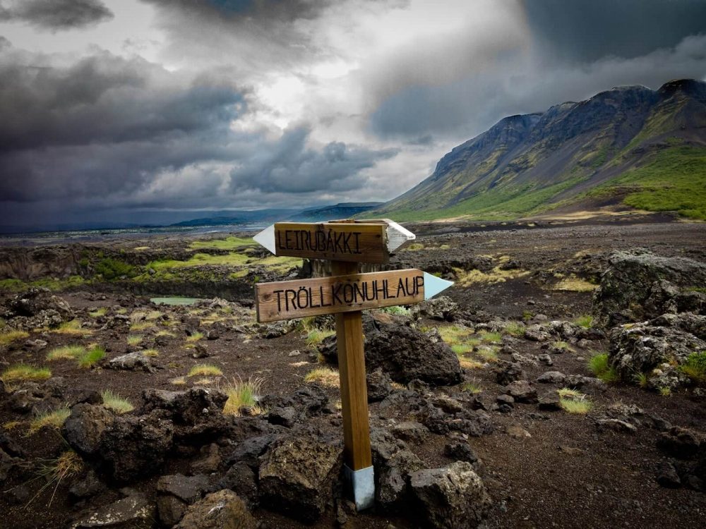 An Icelandic sign with mountains in the background