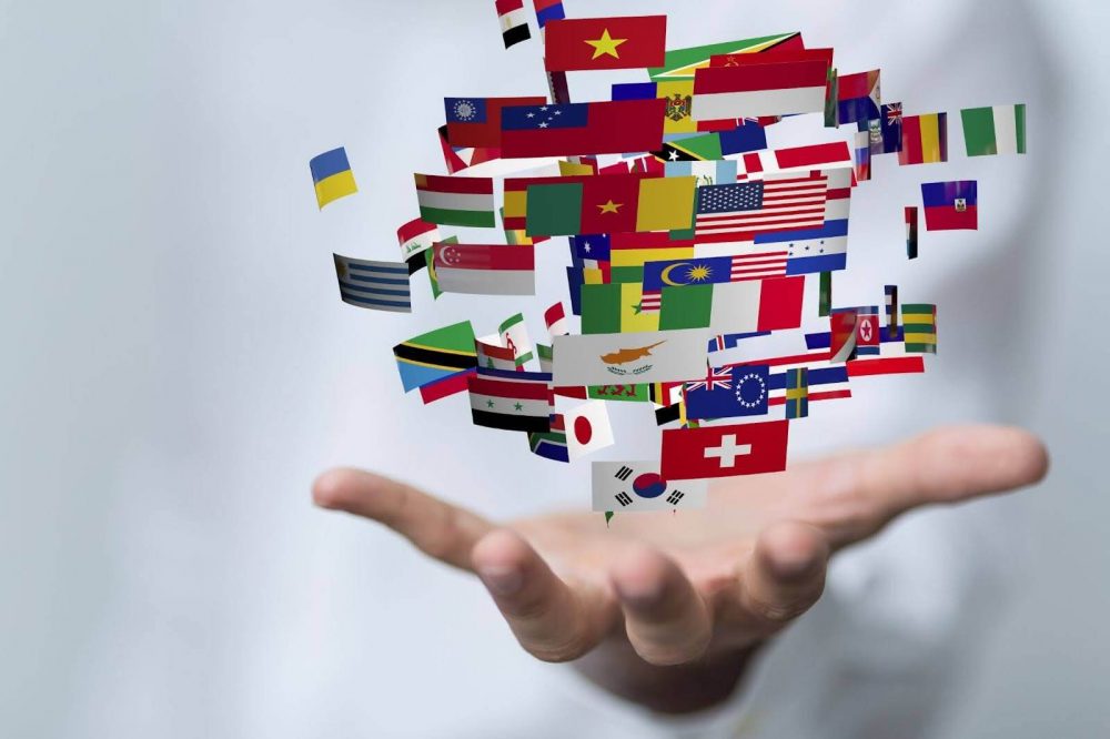 Small international flags above a human hand